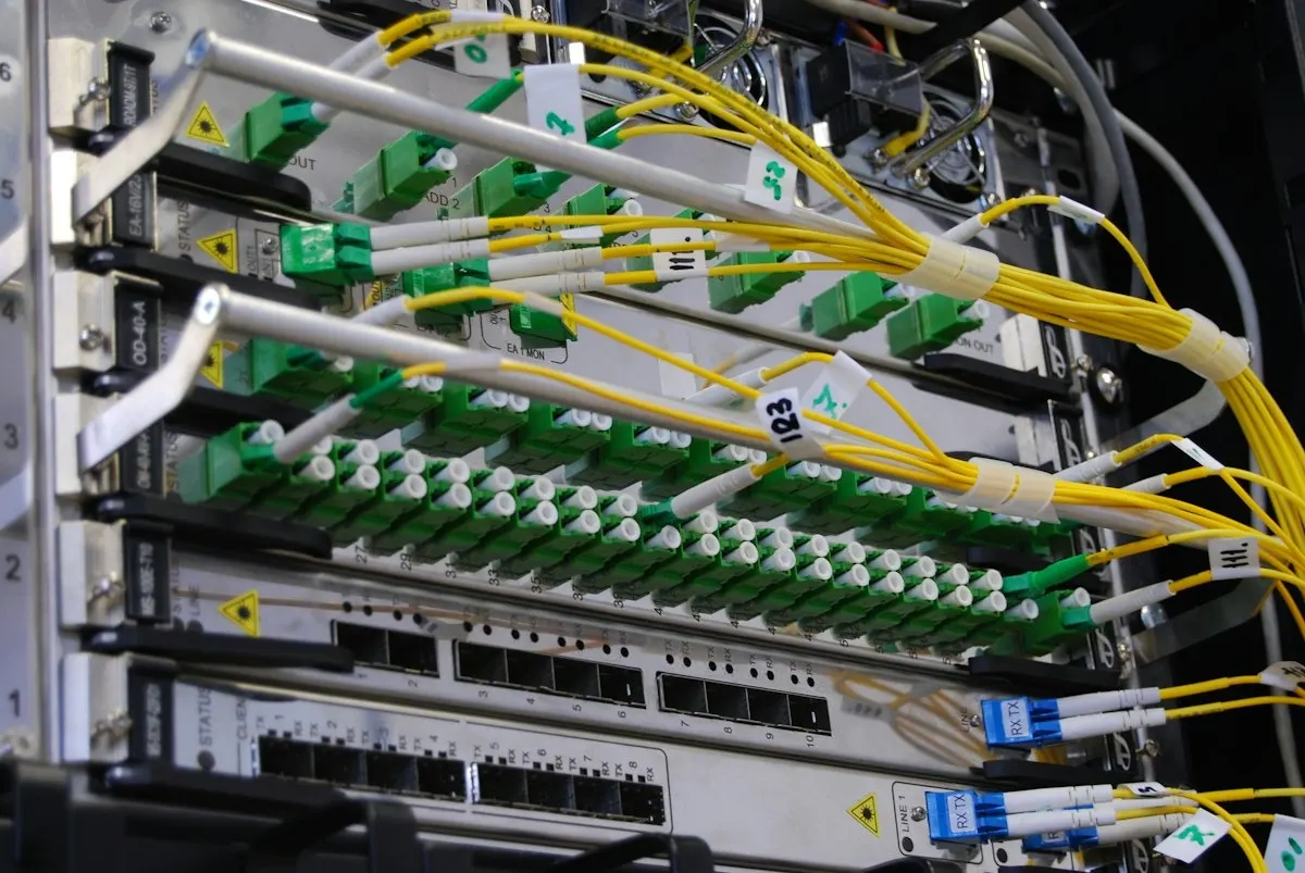 Rack de telecomunicaciones con fibra óptica y equipos de red
