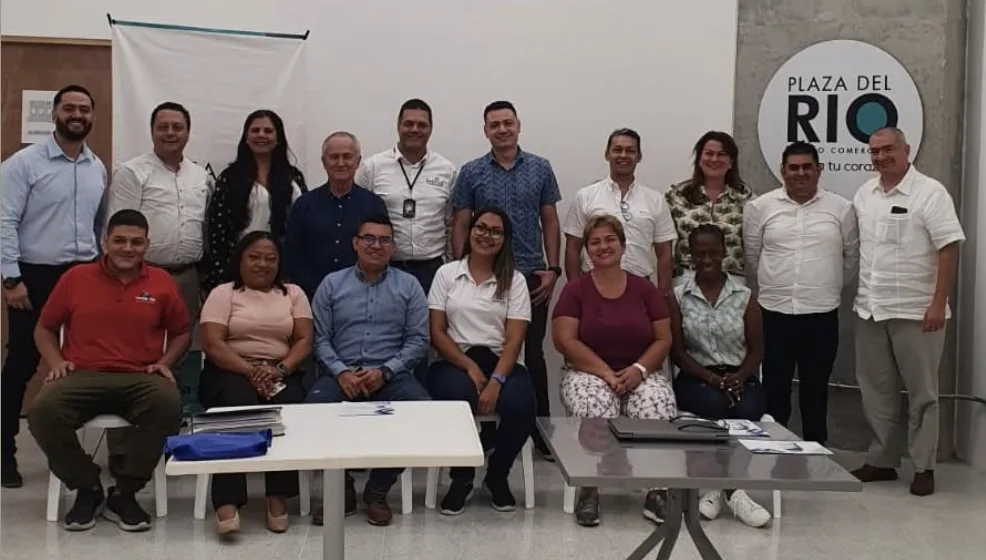 Grupo de unas veinte personas, de pie y sentadas, en la reunión de la Mesa TIC de Fenalco Antioquia en el centro comercial Plaza del Río